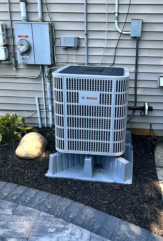 Bosch outdoor unit on a raised stand beside a home