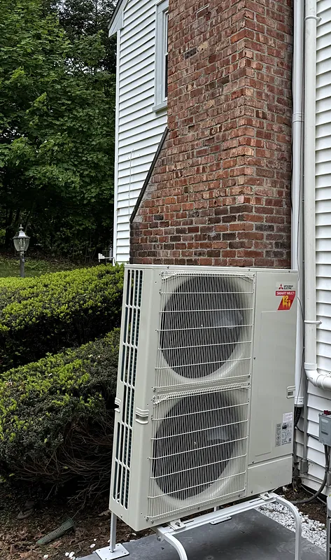 Mitsubishi Electric Smart Multi Hyper-Heat outdoor unit beside a brick chimney